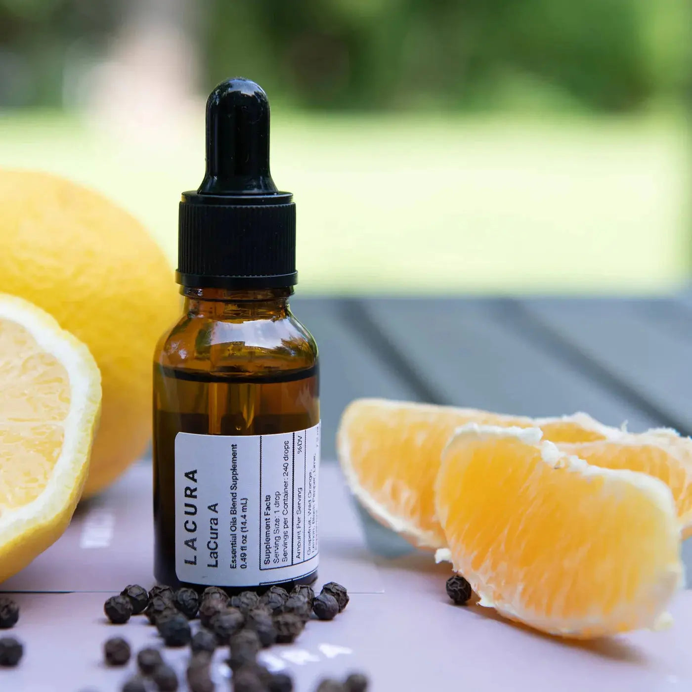 Bottle of Lacura A supplement with lemons and oranges on a blurred natural background